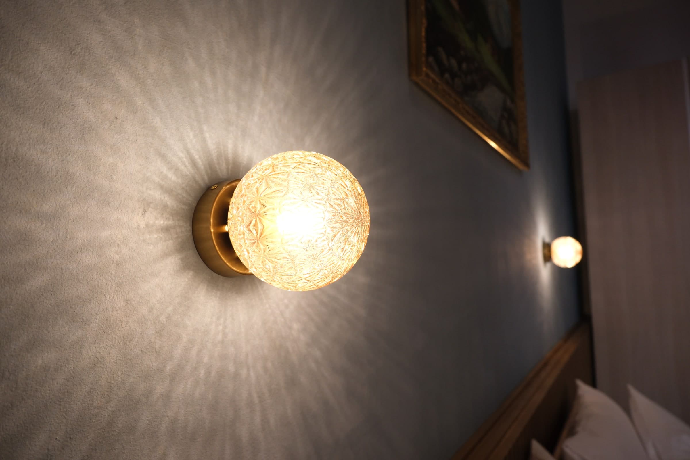 Textured glass bedside light on the blue bedroom wall